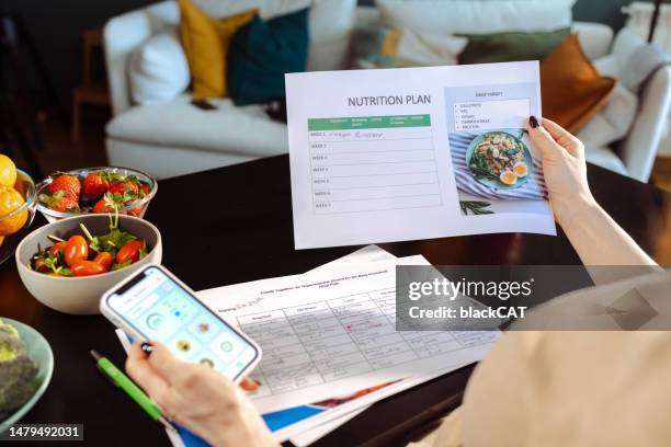 a woman is making a weekly nutrition plan - cholesterol medication stock pictures, royalty-free photos & images