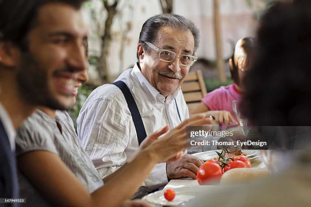 Proud Italian Grandfather having lunch with family