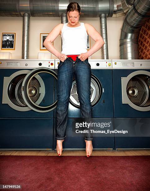 woman trying to fit into a pair of skinny jeans - too small stockfoto's en -beelden