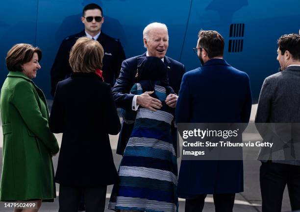 President Joe Biden gives a hug to United States Representative Ilhan Omar and greets the Minnesota delegation as he arrives at Minneapolis-St. Paul...