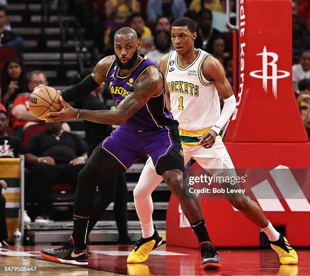 LeBron James of the Los Angeles Lakers receives a pass as Jabari Smith Jr. #1 of the Houston Rockets defends during the third quarter at Toyota...