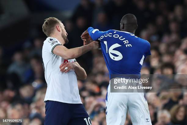 Harry Kane of Tottenham Hotspur and Abdoulaye Doucoure of Everton clash during the Premier League match between Everton FC and Tottenham Hotspur at...