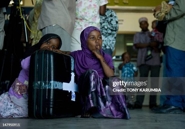 Young girls sit by their family's luggage at Zanzibar's Abeid amani Karume airport on July 6 after being repatriated from Somalia's capital,...