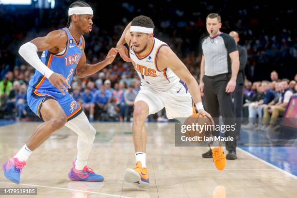 Devin Booker of the Phoenix Suns drives past Shai Gilgeous-Alexander of the Oklahoma City Thunder during the first quarter at Paycom Center on April...