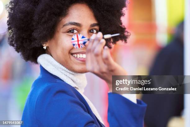 happy afro woman throwing a dart with the england flag - england flag foto e immagini stock