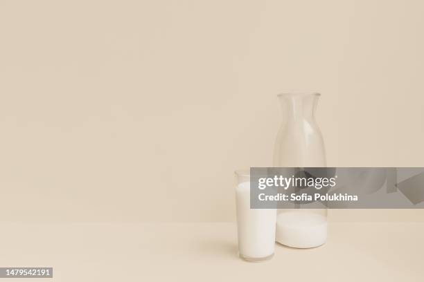 bottle and glass of milk on beige background. - bolsa de cor creme fotografías e imágenes de stock