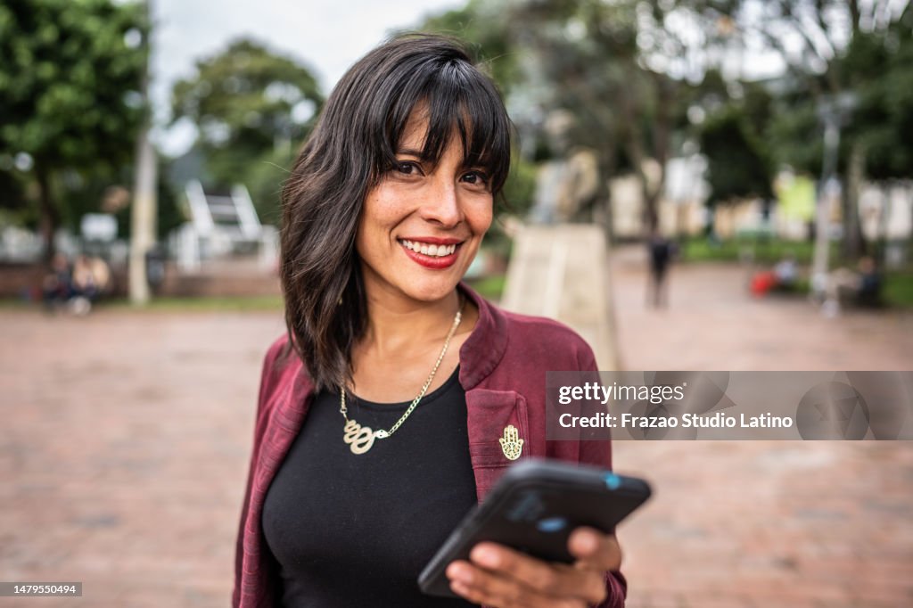 Portrait of a mid adult woman using mobile phone outdoors