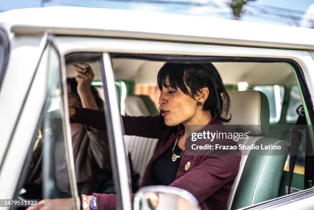 mid adult woman driver having fun during road trip in a retro mini van - car listening to music imagens e fotografias de stock