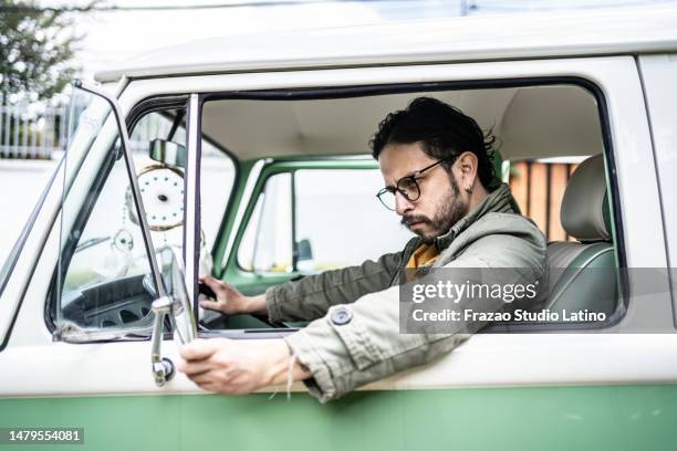 mid adult man adjusting side mirror car in a retro mini van - old car side view stock pictures, royalty-free photos & images