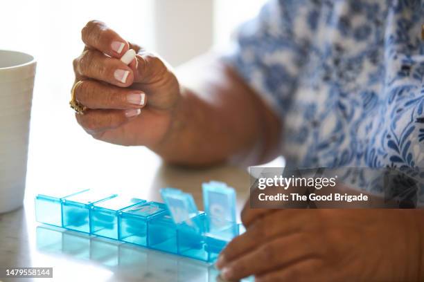 close up senior woman's hands with pill organizer - receptbelagt läkemedel bildbanksfoton och bilder