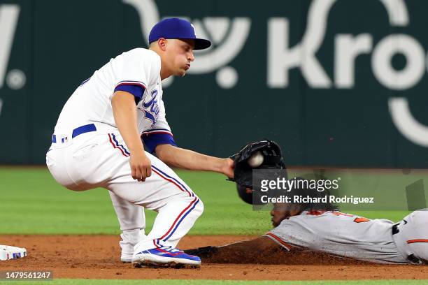 Corey Seager of the Texas Rangers gets the ball as Cedric Mullins of the Baltimore Orioles steals second base in the third inning at Globe Life Field...