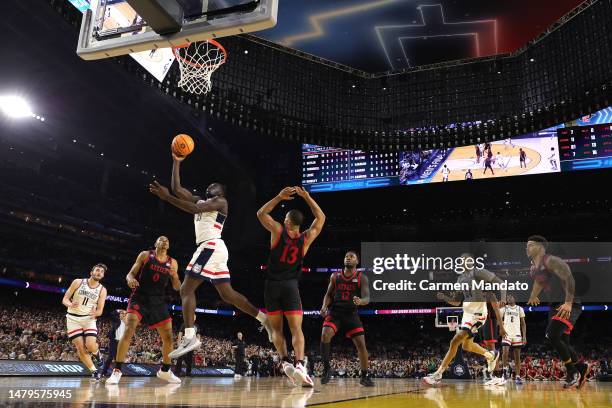Adama Sanogo of the Connecticut Huskies drives to the basket against Keshad Johnson of the San Diego State Aztecs during the second half during the...