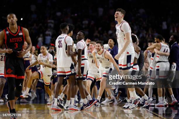 Alex Karaban of the Connecticut Huskies celebrates with teammates after defeating the San Diego State Aztecs 76-59 during the NCAA Men's Basketball...