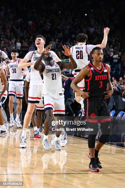 Adama Sanogo and Donovan Clingan of the Connecticut Huskies celebrate after defeating the San Diego State Aztecs to win the NCAA Men's Basketball...