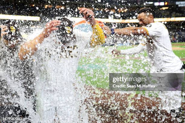 Ha-Seong Kim of the San Diego Padres has a sports drink poured on him by teammate after hitting a walk-off homerun during the ninth inning of a game...