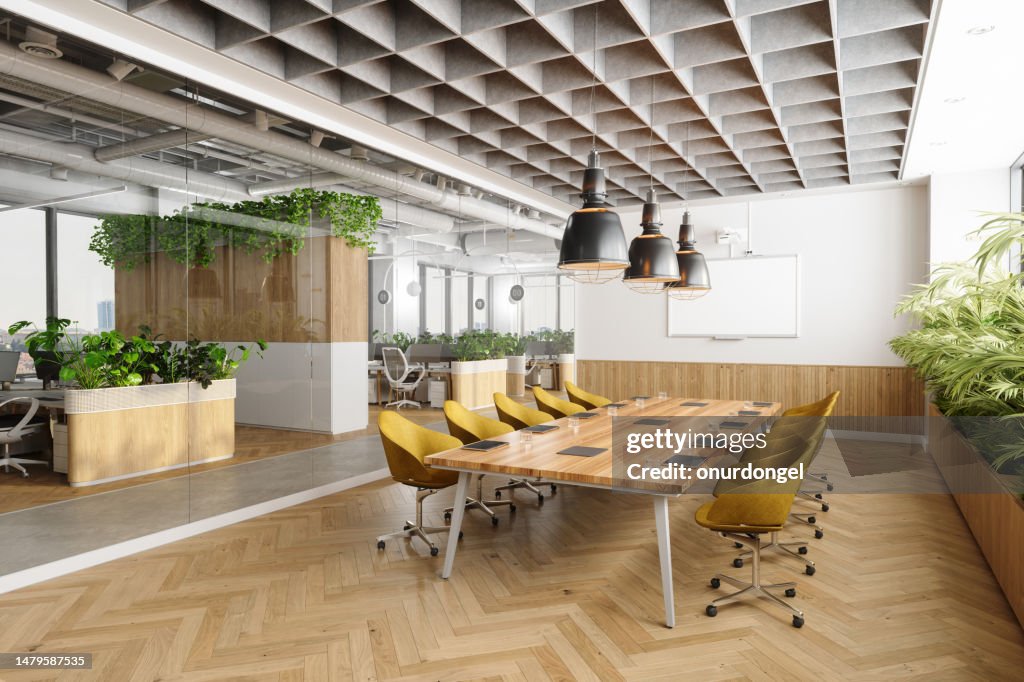 Eco-Friendly Open Plan Modern Office Interior With Meeting Room. Wooden Meeting Table, Yellow Chairs, Plants And Parquet Floor