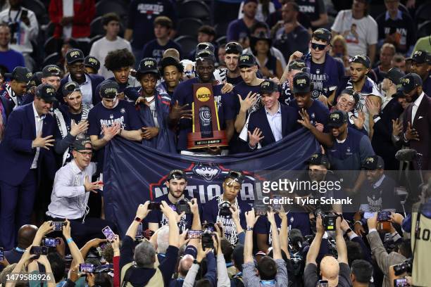 Adama Sanogo of the Connecticut Huskies celebrates with the trophy after defeating the San Diego State Aztecs to win the NCAA Men's Basketball...