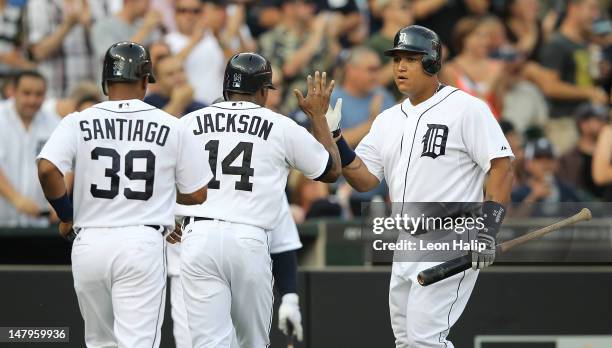 Miguel Cabrera of the Detroit Tigers congratulates teammates Austin Jackson and Ramon Santiago after they scored on a triple to deep center field by...