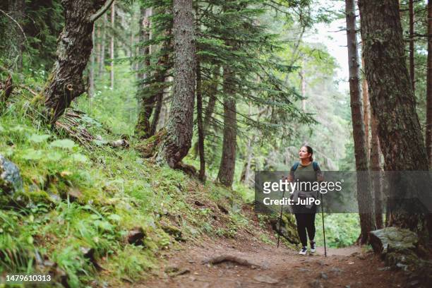 femme adulte randonnant en forêt - walking stick photos et images de collection