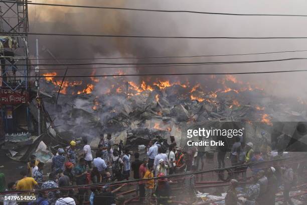 Rescue workers along with Firefighters attempt to tame a fire erupts at the Bangabazar market shopping complex on April 4, 2023 in Dhaka, Bangladesh....