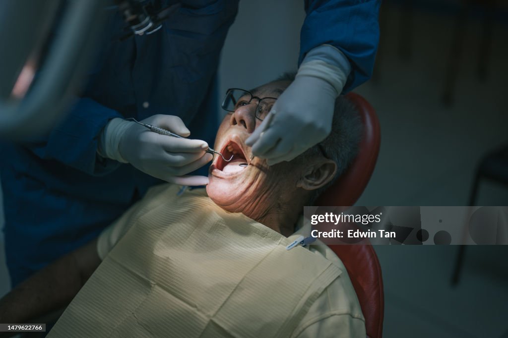 Close up Asian Chinese senior patient open mouth for dentist examining tooth routine check up