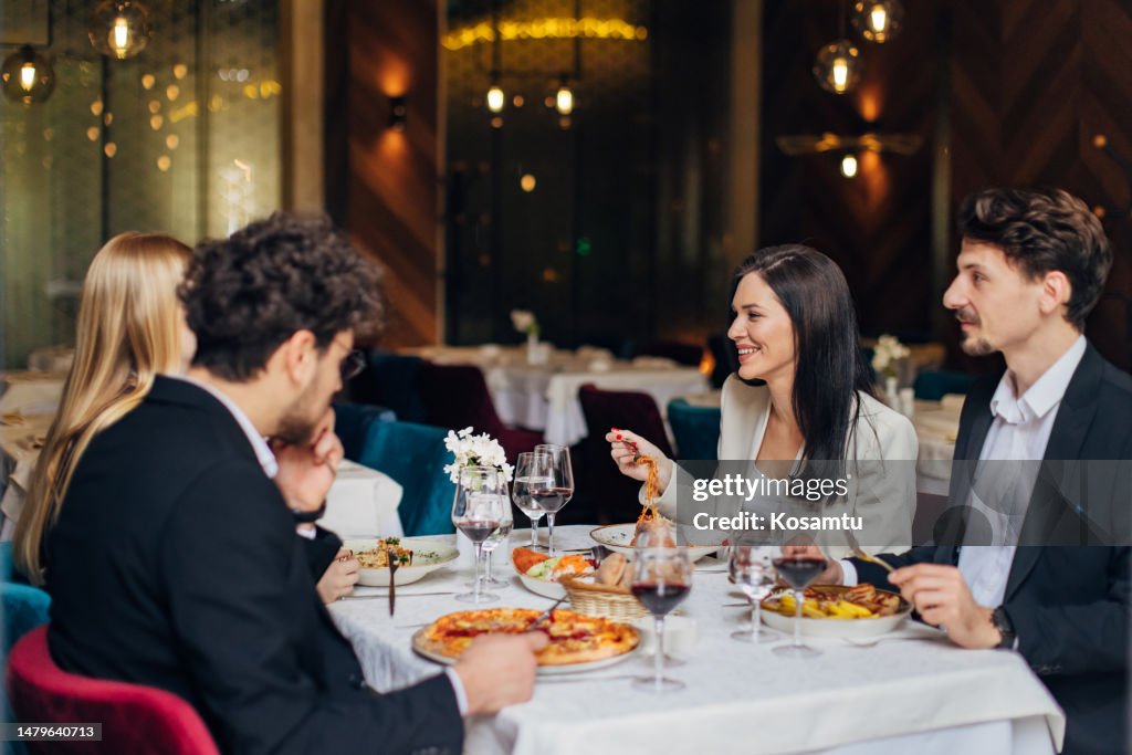 Eine kleine Gruppe von Unternehmern, die sich bei einem Geschäftsessen in einem Restaurant amüsieren