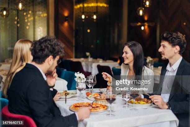 un pequeño grupo de emprendedores divirtiéndose durante un almuerzo de negocios en un restaurante - servicio de calidad fotografías e imágenes de stock