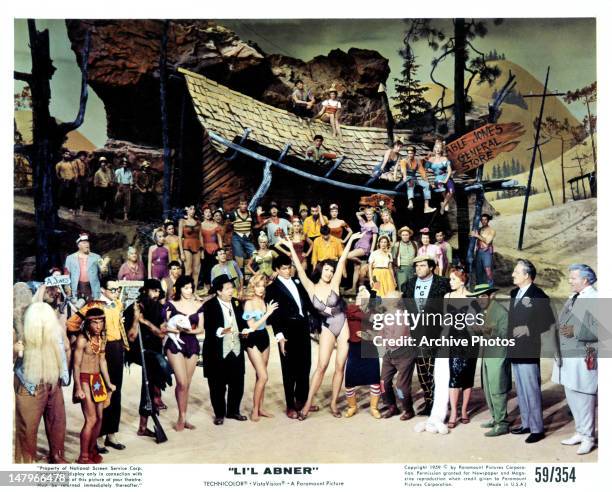 Stubby Kaye, Leslie Parrish, Julie Newmar, and townspeople gather in a scene from the film 'Li'l Abner', 1959.