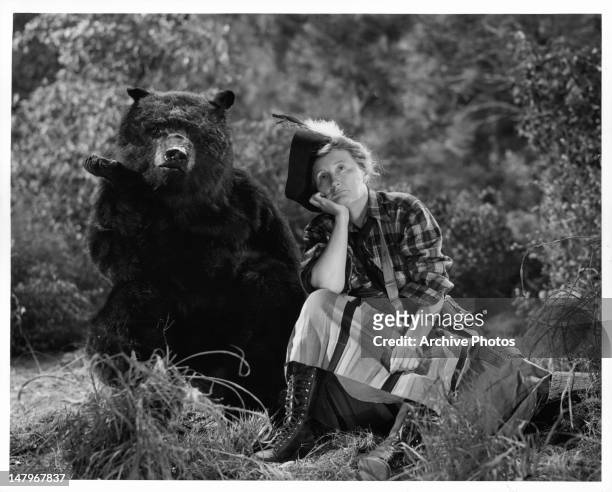 Marjorie Main relaxing with bear in a scene from the film 'Tish', 1942.