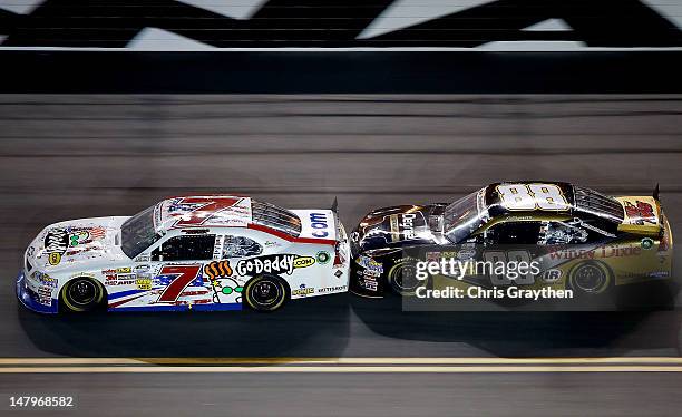 Danica Patrick, driver of the GoDaddy.com/NASCAR Unites An American Salute Chevrolet, leads Cole Whitt, driver of the Degree Men ChevroleCole Whitt,...