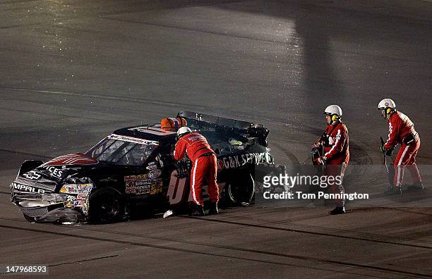 Officials check on Mike Wallace, driver of the G&K Services Chevrolet, after he spun during the NASCAR Nationwide Series Subway Jalapeno 250 Powered...