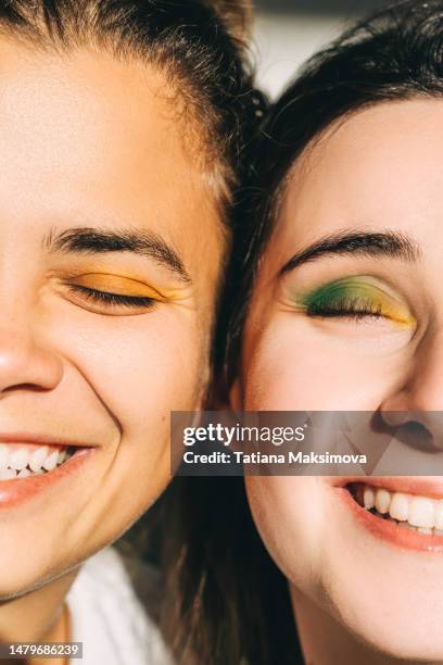 two young beautiful women with bright make-up close-up. diversity concept. - pittura per il viso foto e immagini stock
