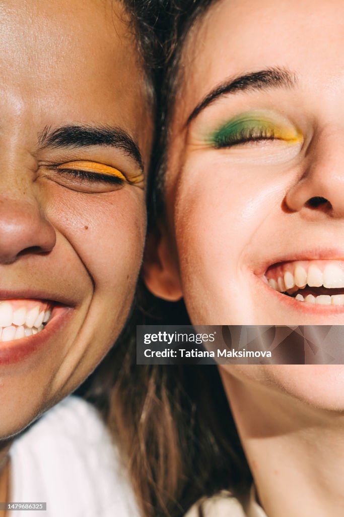 Two young beautiful women with bright make-up close-up. Diversity concept.