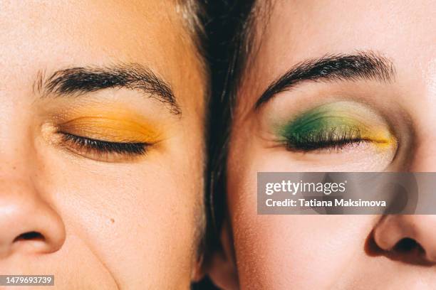 two young beautiful women with bright make-up close-up. diversity concept. - maquillaje-ceremonial fotografías e imágenes de stock