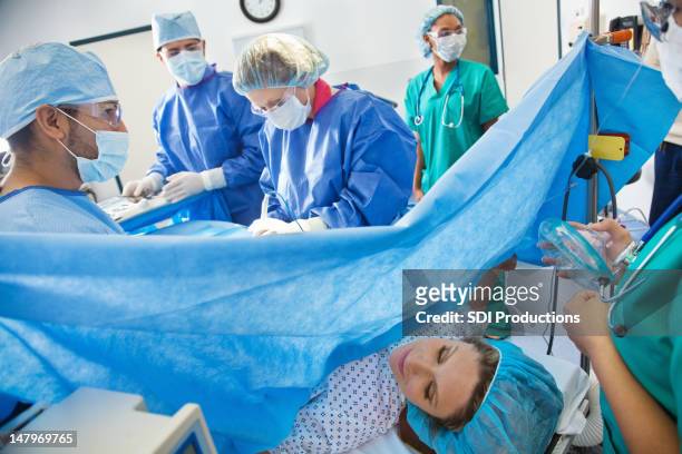 team chirurgico eseguito taglio cesareo su donna incinta - operating room foto e immagini stock