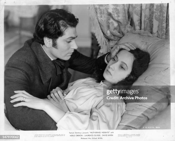 Laurence Olivier at the bedside of Merle Oberon in a scene from the film 'Wuthering Heights', 1939.