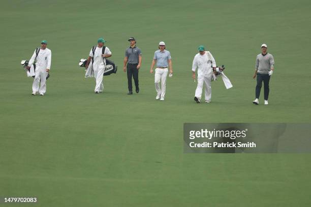 Amateur Harrison Crowe of Australia, Cameron Smith of Australia, and Adam Scott of Australia walk down the second fairway during a practice round...