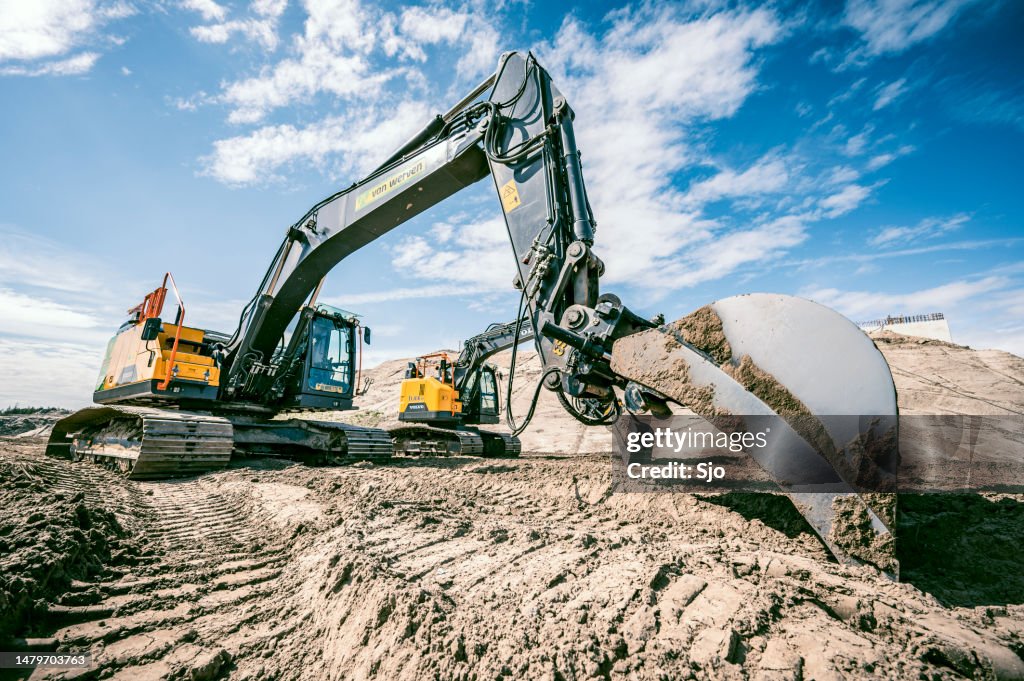Excavator machine on a construction site with a smaller excavator in the background