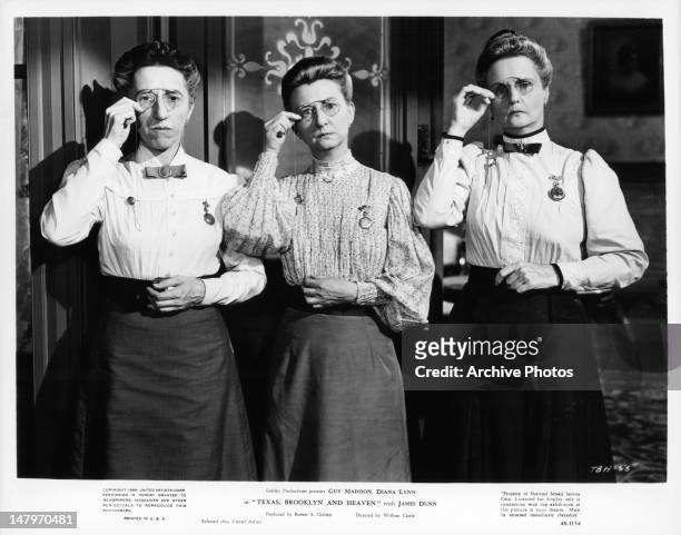 Margaret Hamilton, Irene Ryan, and Moyna Magill adjust their glasses in a scene from the film 'Texas, Brooklyn & Heaven', 1948.