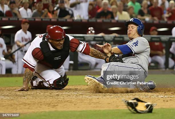 Mark Ellis of the Los Angeles Dodgers is tagged out at home plate by catcher Henry Blanco of the Arizona Diamondbacks as he attempted to score in the...