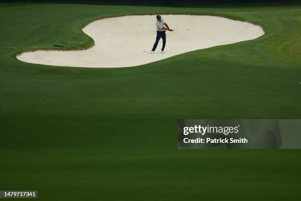 Tiger Woods of the United States plays a shot from a bunker on the fourth hole during a practice round prior to the 2023 Masters Tournament at...