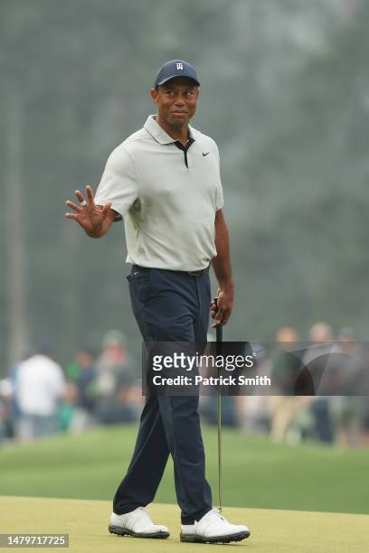Tiger Woods of the United States waves on the third greenduring a practice round prior to the 2023 Masters Tournament at Augusta National Golf Club...