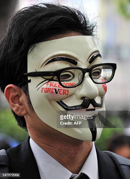 Man wearing a mask displaying the wording "Freedom Forever!" attends a clean up mission organised by hacker collective Anonymous on a street in Tokyo...