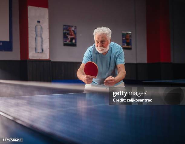 senior man plays table tennis in tehe hall - table tennis stock pictures, royalty-free photos & images