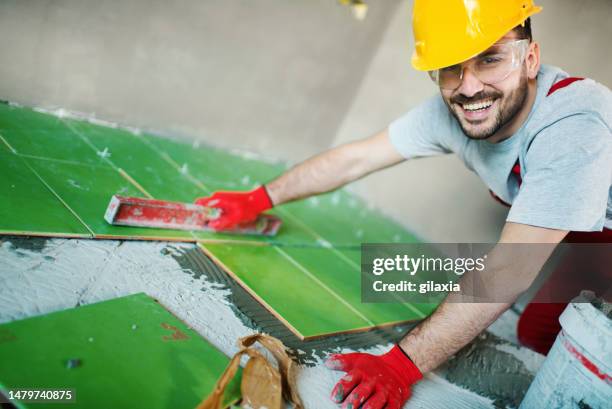 handyman installant des carreaux en céramique. - truelle photos et images de collection