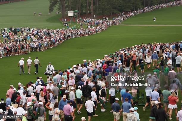 Fred Couples of the United States, Justin Thomas of the United States and Tiger Woods of the United States walk to the eighth fairway during a...