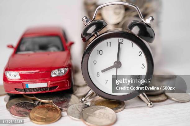 car and alarm clock on coins,car loan,finance,saving money,insurance and leasing time concepts,romania - home economics ストックフォトと画像