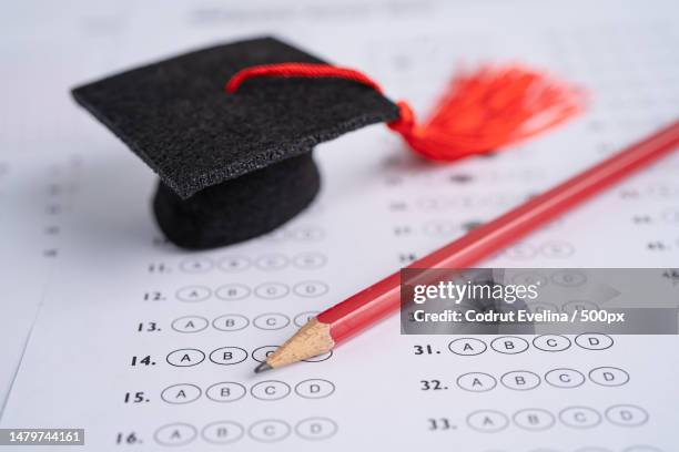 graduation gap hat and pencil on answer sheet background,education study testing learning teach con,romania - the bachelor stockfoto's en -beelden