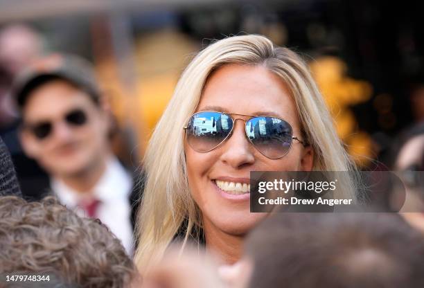 Rep. Marjorie Taylor Greene walks through the crowd gathered outside the courthouse where former U.S. President Donald Trump will arrive later in the...