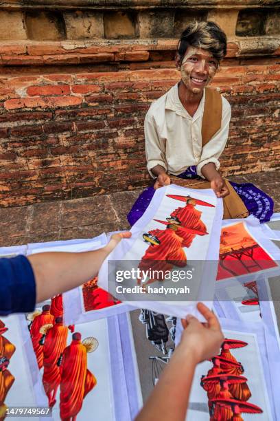 young burmese boy selling sand paintings in bagan, myanmar - painting art product stock pictures, royalty-free photos & images